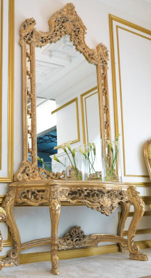 Luxe gesneden console tafel en spiegel in een elegante omlijsting.