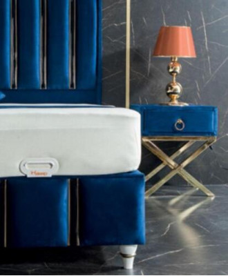 Saffierblauw designbed met nachtkastjes op vergulde stalen poten.