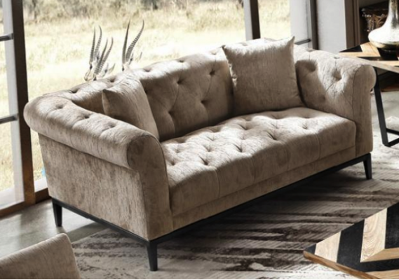 Gezellige beige Chesterfield driezitsbank voor in de woonkamer.
