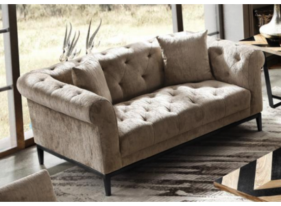 Gezellige beige Chesterfield driezitsbank voor in de woonkamer.