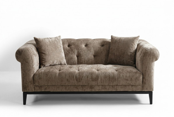 Gezellige beige Chesterfield driezitsbank voor in de woonkamer.