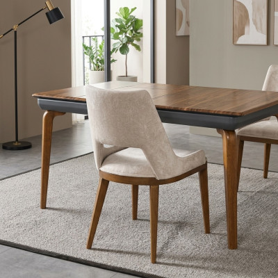 Een laconieke, moderne stoel met hoge poten van hout en bekleding in een prettige, lichte crèmekleur voor de eetkamer.