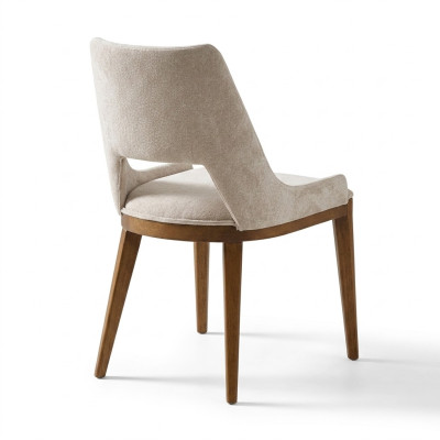 Een laconieke, moderne stoel met hoge poten van hout en bekleding in een prettige, lichte crèmekleur voor de eetkamer.