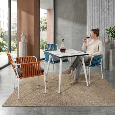 Originele stoelen in een lichte oranje kleur op witte poten van roestvrij staal met een zacht kussen.