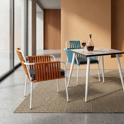 Originele stoelen in een lichte oranje kleur op witte poten van roestvrij staal met een zacht kussen.