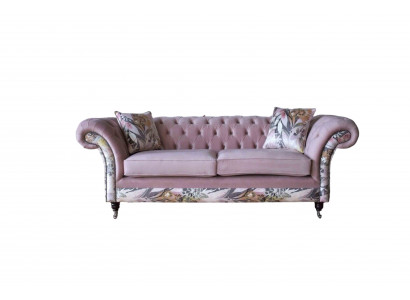 Een levendige driezitsbank van Chesterfield met een delicaat roze bloemenpatroon.